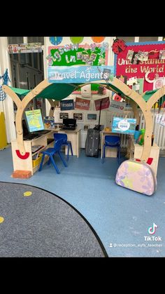 the children's play area is set up with wooden trees and colorful signs on the walls