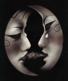 two masks with faces painted on them in the shape of crescents, one is black and white