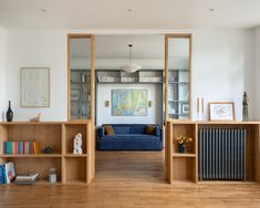 a living room filled with furniture and bookshelves on top of wooden flooring