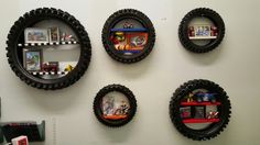 four round black frames with legos on them are hanging on the wall next to bookshelves