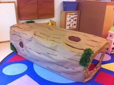 a child's play area with a fake tree trunk on the floor