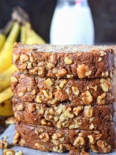 three pieces of banana nut bread stacked on top of each other with bananas in the background