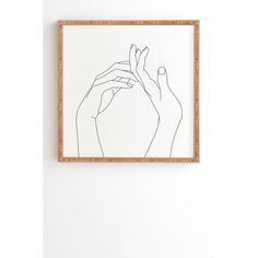 two hands are holding each other in front of a white wall with a wooden frame