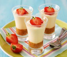 three desserts on a plate with strawberries