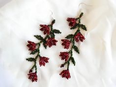 red and green beaded flowers on white fabric