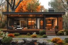 a small house in the woods surrounded by rocks and trees with orange leaves on them