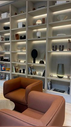 a living room filled with lots of furniture and bookshelves covered in white shelves