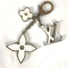 a keychain with the letter l on it and a flower in the middle