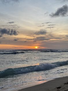 the sun is setting over the ocean with waves