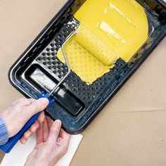 a person using a yellow mop on top of a black and white floor mat