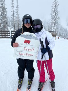 two people on skis holding up a sign that says prun? and is wearing goggles