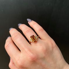 a woman's hand with a ring on it and two stones in the middle