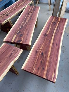 three pieces of wood sitting next to each other on top of a cement flooring area