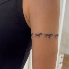 a woman's arm with three horses on it