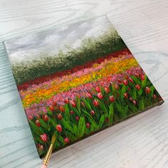 an acrylic painting of tulips and other flowers on a table with a brush