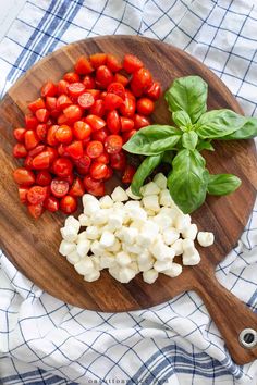 tomatoes, mozzarella and basil on a wooden cutting board