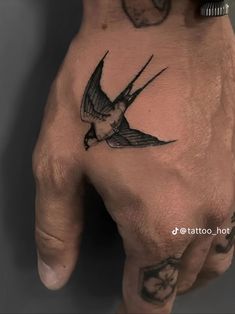 a person's hand with a bird tattoo on it