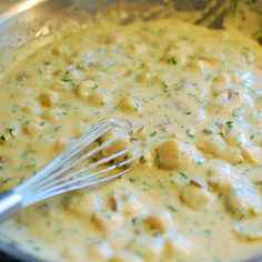 a metal bowl filled with food and a whisk on top of the mixture