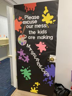 Door decorated for preschool room. Black background with paint splatters all over in all colors. Hand held easel with paint and paintbrush. Words in white say “please excuse our mess the kids are making masterpieces” Please Excuse Our Mess Classroom Door, Classroom Door Painting Ideas, Beggining Of The Year Preschool, Colors And Shapes Door Decorations, Preschool Hallway Ideas, What A Mess Vbs Decorations, Art Bulletin Boards Preschool, Vbs Door Decorations, Art Door Decorations Classroom