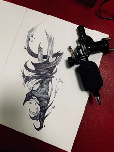 an ink drawing of a dragon on paper next to a pen and ink splatter