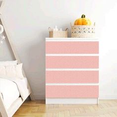 a white bed sitting next to a pink dresser