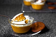 a spoon with some food in it sitting on a table next to other desserts