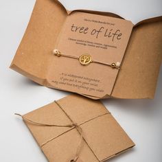 an open book with a tree of life charm on the front and inside, tied in twine