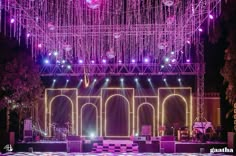 the stage is lit up with purple lights and chandelier hanging from the ceiling