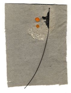 an embroidered piece of cloth with two orange flowers on the left and one black flower on the right