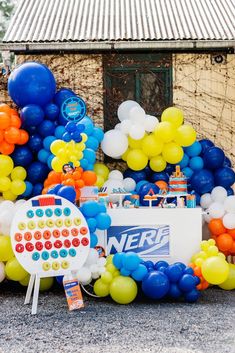 an assortment of balloons and decorations for a nerf birthday party in front of a building