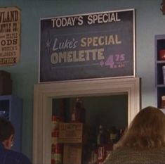 two people standing in front of a sign that reads today's special luke's special omelette