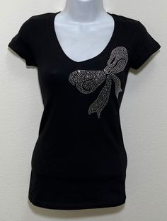 Fabric comprised of 95% cotton and 5% spandex.  Handmade rhinestone t-shirts made in the United States with quality rhinestones. Machine washable. T-shirt style is a fitted V-neck cap sleeve. Size Range:         XXS = 2         XS = 4         S = 6         M = 8         L = 10         XL = 12 Rhinestone Cotton Tops With Short Sleeves, Cotton Rhinestone Short Sleeve Top, Cotton Short Sleeve Top With Rhinestones, Cotton Tops With Rhinestones And Short Sleeves, Cotton T-shirt With Rhinestones And Short Sleeves, Cotton Short Sleeve T-shirt With Rhinestones, Cotton T-shirt With Rhinestones Short Sleeve, Embellished Fitted Cotton T-shirt, Fitted Cotton Embellished T-shirt