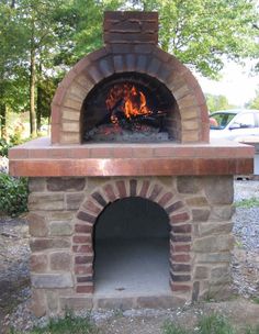 an outdoor brick oven with fire in it