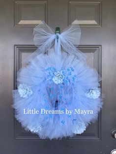 a blue and white tulle wreath hanging on a door with the words little dreams by mayra