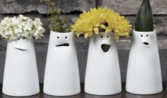 four white vases with yellow flowers in them