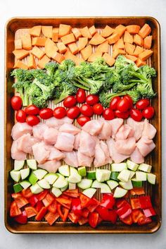 a platter filled with meat, veggies and tomatoes