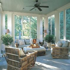 a sun room with wicker furniture and large windows