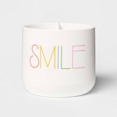 a white cup with the word smile painted on it