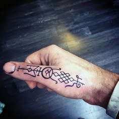 a hand with a small tattoo on it