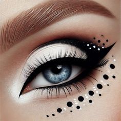 This image showcases a beautifully executed black and white eye makeup look. The eye is adorned with a dramatic winged eyeliner that extends outward, complemented by a gradient of white and black eyeshadow. The makeup artist has added a creative touch with a series of black and white dots of varying sizes around the eye, creating a unique and artistic effect. The precision and contrast in this makeup make it a stunning example of creative eye art, perfect for those looking to make a bold statement.  #EyeMakeup #BlackAndWhiteMakeup #CreativeMakeup #MakeupArt #DramaticEyes #WingedEyeliner #MakeupInspiration #Beauty #MakeupLover #ArtisticMakeup