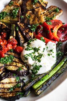 a white plate topped with grilled vegetables and feta cheese