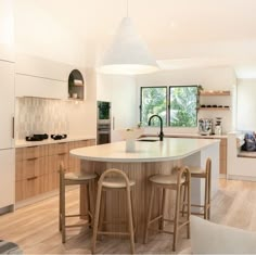 a kitchen with two stools and an island in front of a window that looks out onto the outdoors