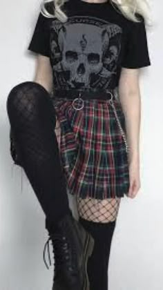 a woman with white hair wearing a black t - shirt, plaid skirt and knee high boots