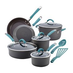 an assortment of pots and pans on a white background with utensils in the foreground