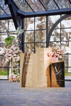 two brown paper bags sitting next to each other on top of a stone floor with flowers