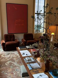 a living room filled with furniture and a painting on the wall