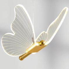 a white and gold butterfly light hanging from a string with two lights attached to it