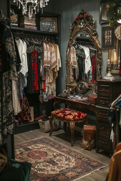 a dressing room with an ornate mirror, chandelier and clothes on hangers