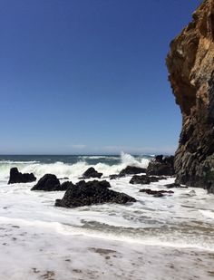 the waves are crashing on the rocks at the beach