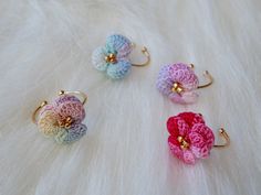 three crocheted flower rings sitting on top of a white fur